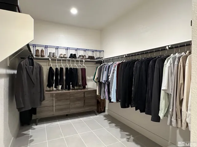 a view of walk in closet with clothes and shoes