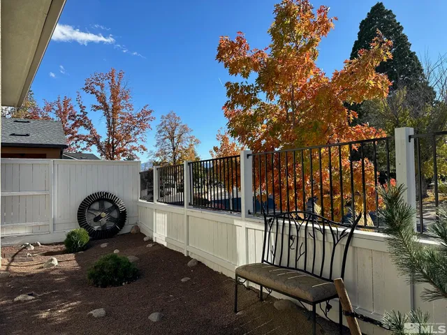 a view of a street with flower plants and covered with tall trees
