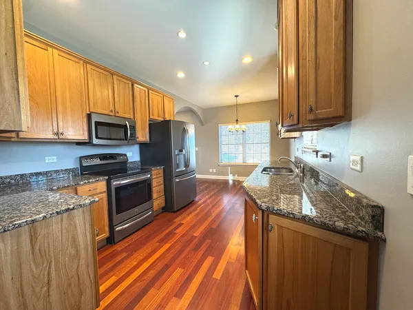 a kitchen with granite countertop stainless steel appliances a stove top oven a sink and a granite counter tops