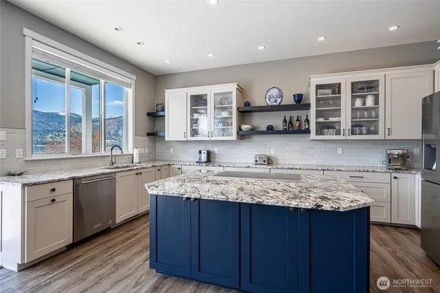 a kitchen with stainless steel appliances granite countertop a sink and wooden cabinets