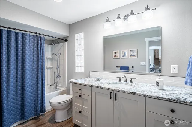 a bathroom with a granite countertop sink toilet and shower