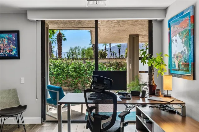 a view of a dining room with furniture a chandelier and large window