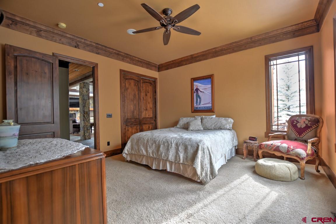 302 Maverick Lane Montrose, CO 81403 - Photo 23 of 35 a bedroom with a bed and a chandelier
