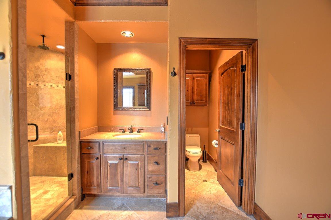 302 Maverick Lane Montrose, CO 81403 - Photo 32 of 35 a en suite bathroom with a granite countertop sink and a mirror