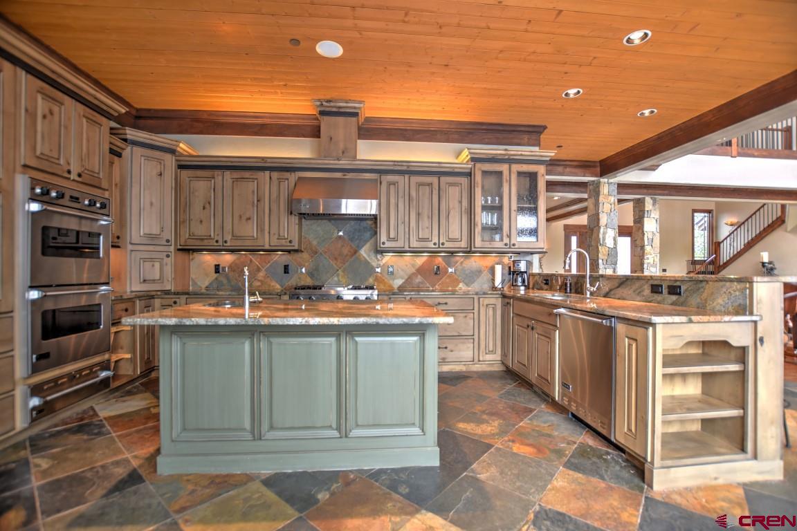 302 Maverick Lane Montrose, CO 81403 - Photo 9 of 35 a kitchen with stainless steel appliances granite countertop a stove a sink and a refrigerator