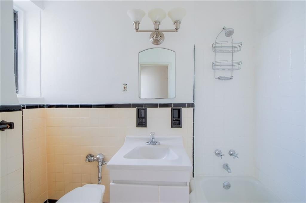 7259 Shore Road, Unit 6G Brooklyn, NY 11209 - Photo 10 of 30 a bathroom with a sink a toilet and mirror