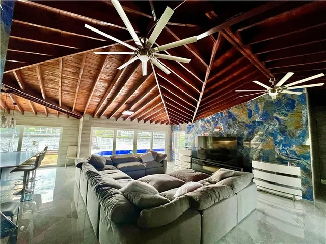 a living room with furniture a flat screen tv and a glass door
