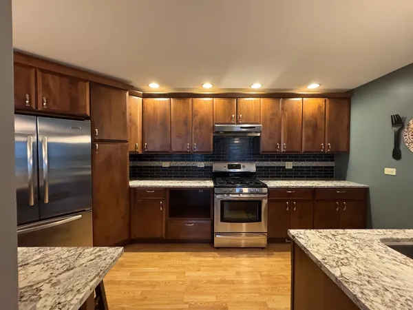 a kitchen with stainless steel appliances granite countertop a stove a refrigerator and a sink