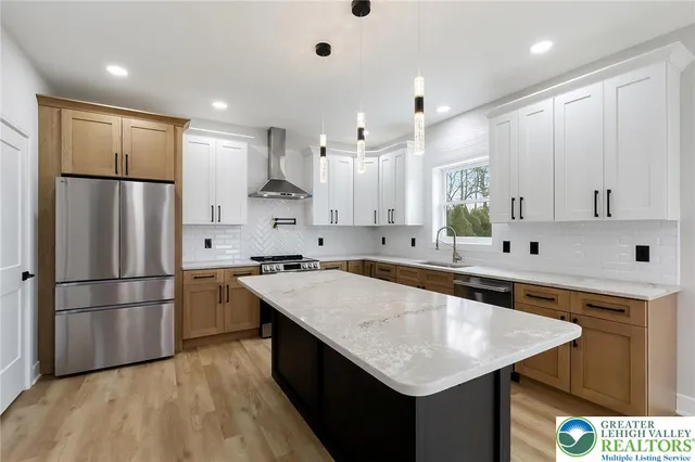 a kitchen with refrigerator a sink a stove and white cabinets