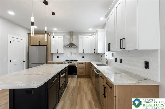 a kitchen with stainless steel appliances a stove a refrigerator and cabinets