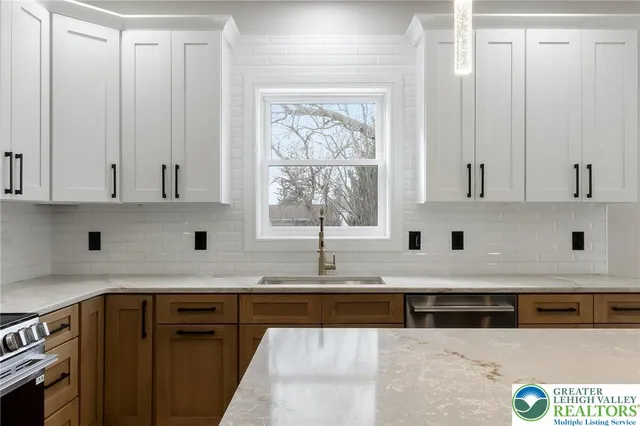 a kitchen with stainless steel appliances kitchen island granite countertop a refrigerator a stove top oven and a dining table with wooden floor