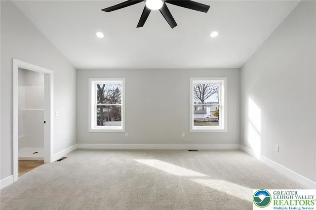 an empty room with ceiling fan and window