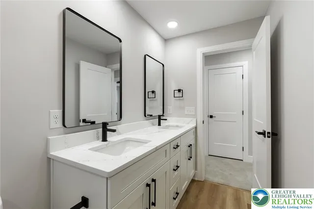 a bathroom with a granite countertop sink a toilet a mirror and shower