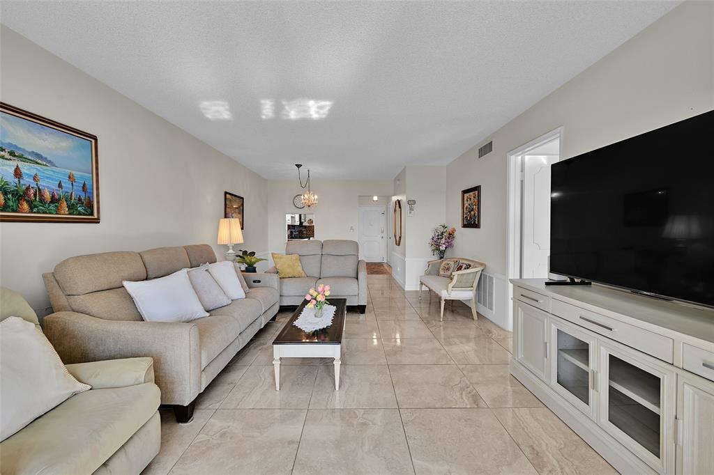 2350 Northeast 14th Street Causeway, Unit 609 Pompano Beach, FL 33062 - Photo 3 of 42 a living room with furniture and a flat screen tv