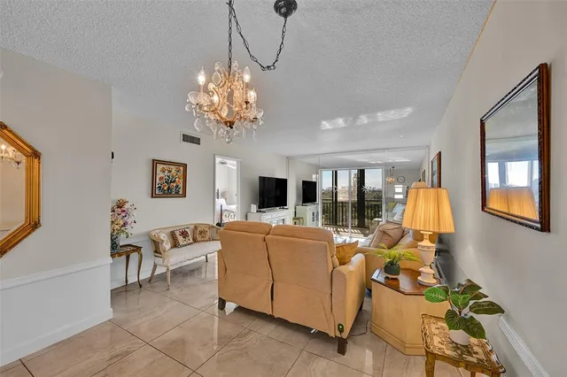 a living room with furniture a chandelier and a flat screen tv