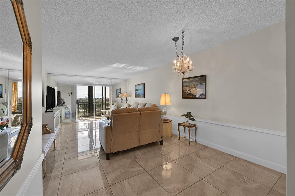 2350 Northeast 14th Street Causeway, Unit 609 Pompano Beach, FL 33062 - Photo 7 of 42 a living room with furniture a chandelier and a dining table