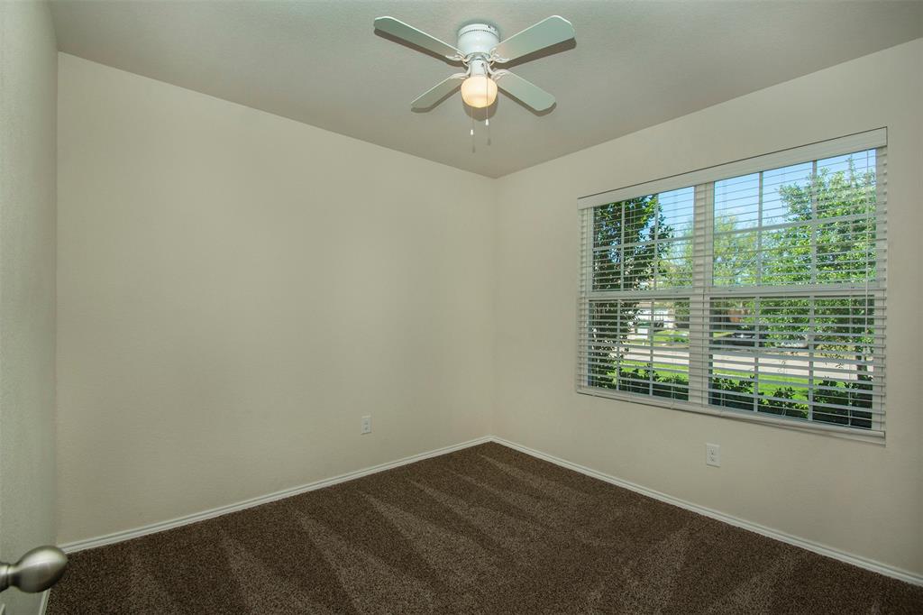 1423 Swan Ridge Drive Sherman, TX 75092 - Photo 2 of 21 Empty room with dark colored carpet and a ceiling fan