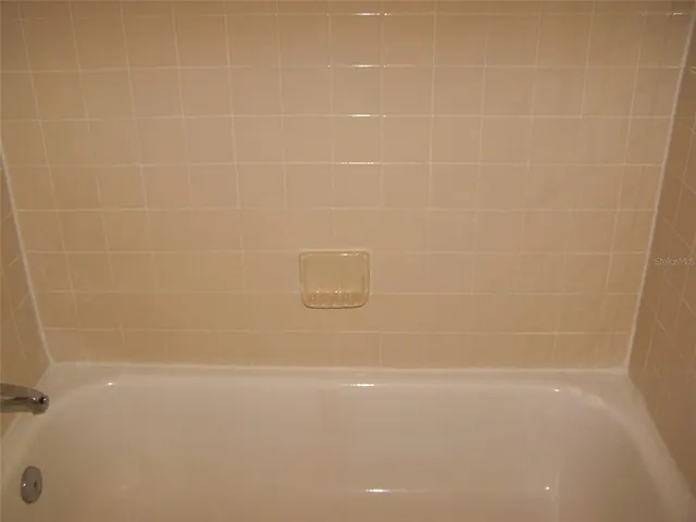 a front view of a house with a yard and potted plants