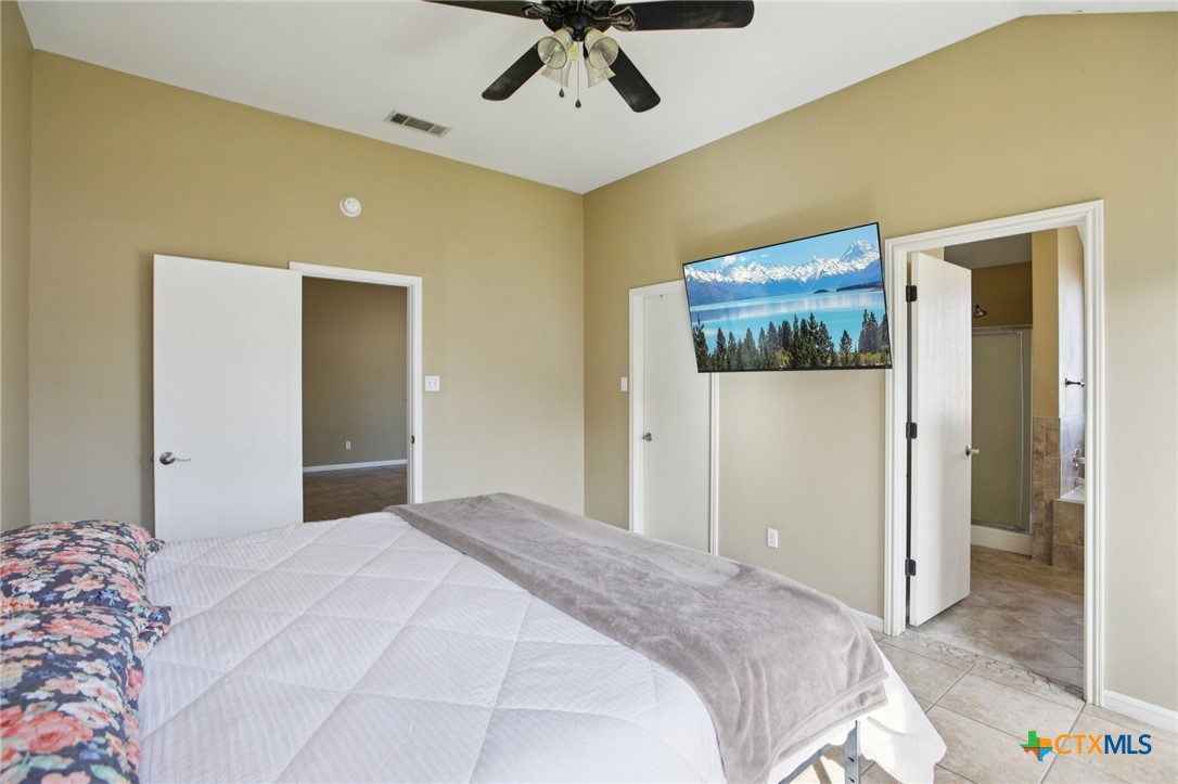 7114 Pappus Court Temple, TX 76502 - Photo 16 of 28 a bedroom with a bed and a chandelier