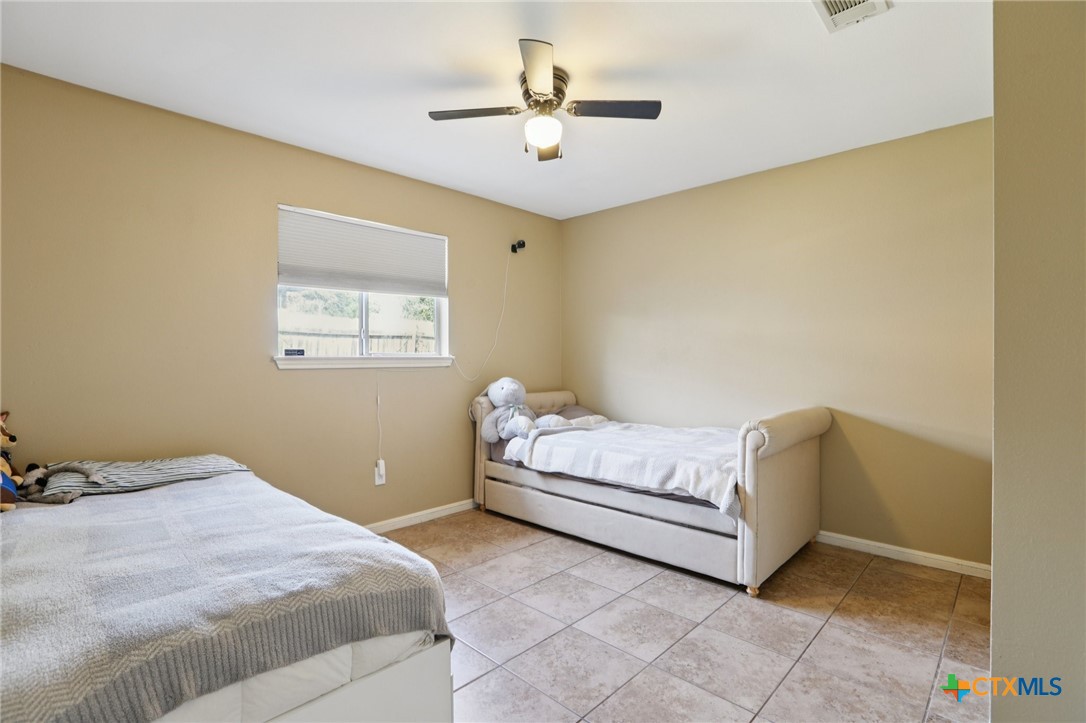 7114 Pappus Court Temple, TX 76502 - Photo 21 of 28 a bedroom with a bed and a chandelier