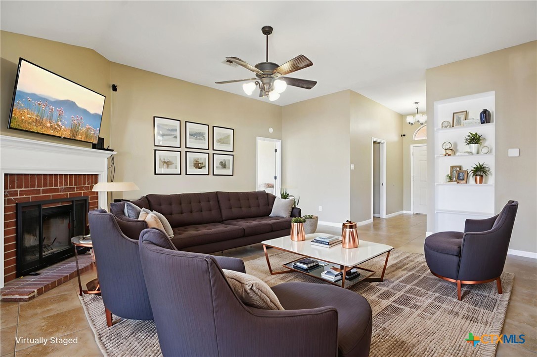 7114 Pappus Court Temple, TX 76502 - Photo 6 of 28 a living room with furniture a fireplace and a large window