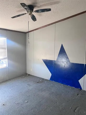 a view of an empty room with a ceiling fan and wooden floor