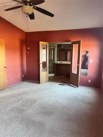 a view of empty room with a ceiling fan and a window