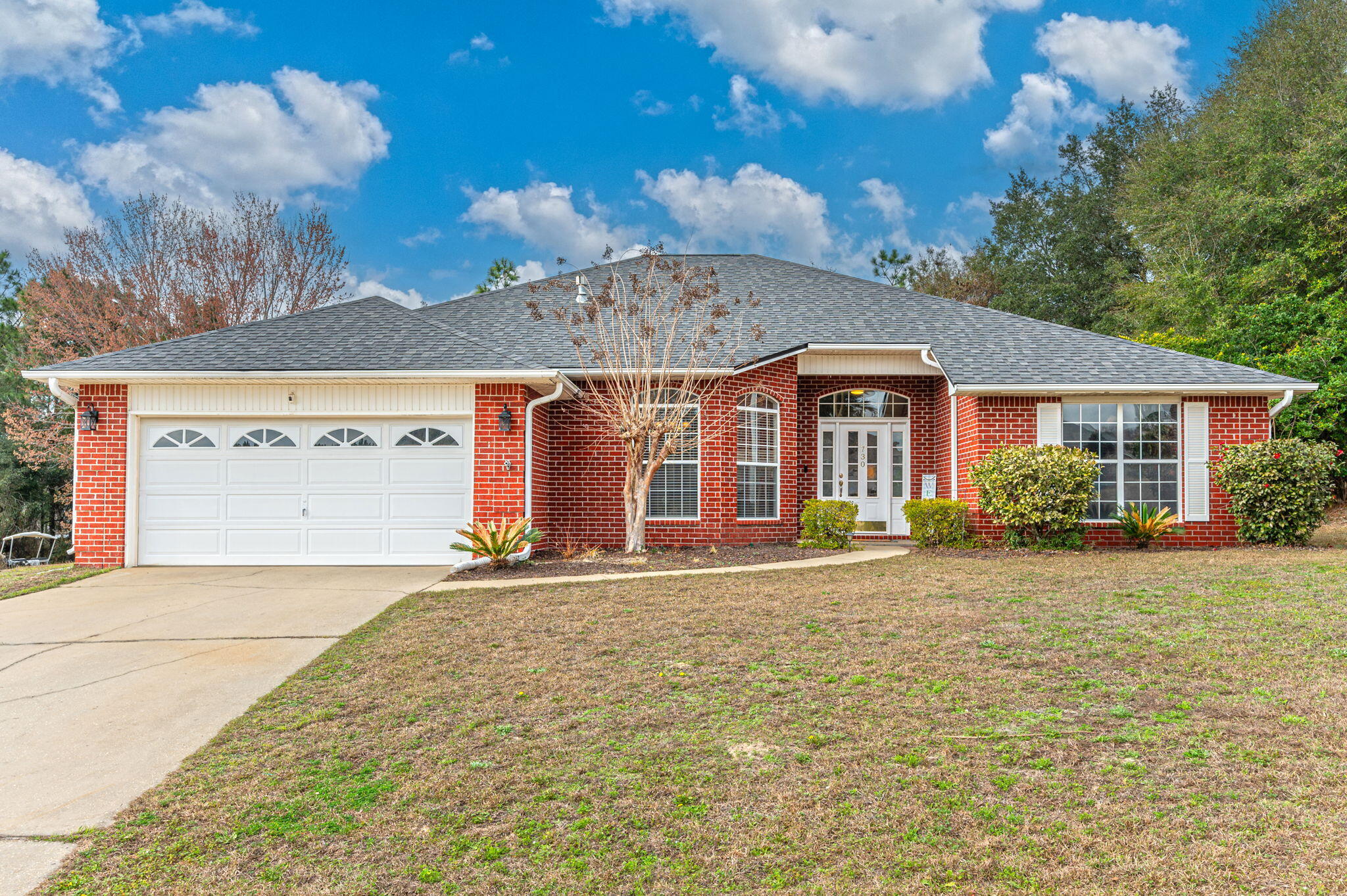 730 Denise Drive Crestview, FL 32536 - Photo 2 of 40 a front view of a house with a garden and trees