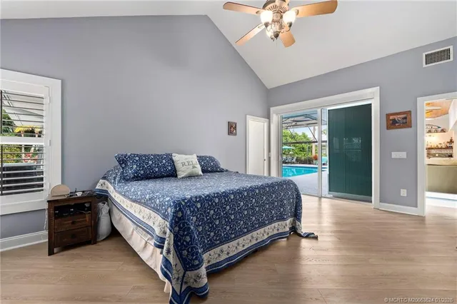 a bedroom with a large bed and a chandelier fan