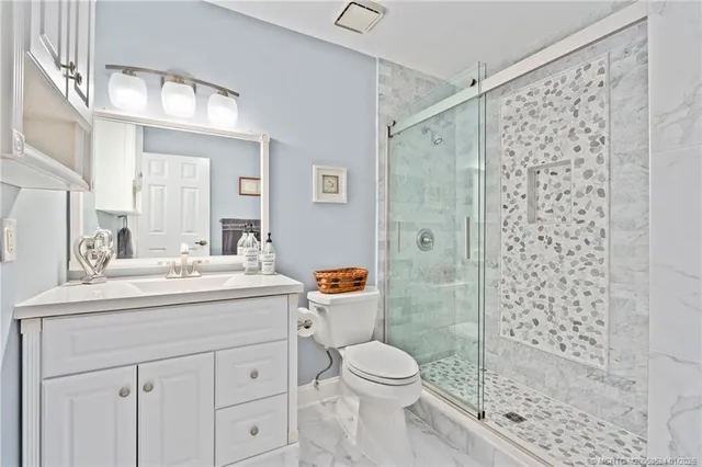 a bathroom with a sink a toilet and shower