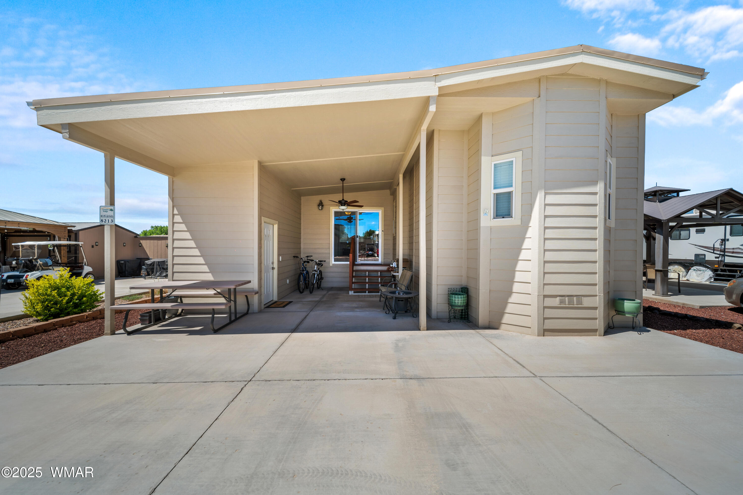 8213 Apache Way, Unit 415 Show Low, AZ 85901 - Photo 1 of 16 a view of a patio with table and chairs potted plants with wooden fence