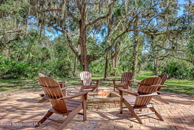 a backyard of a house with lots of green space and seating area
