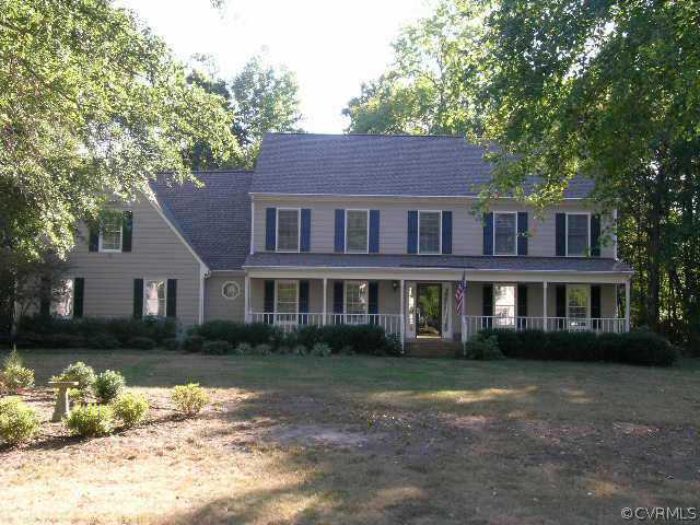 a front view of a house with a garden and trees