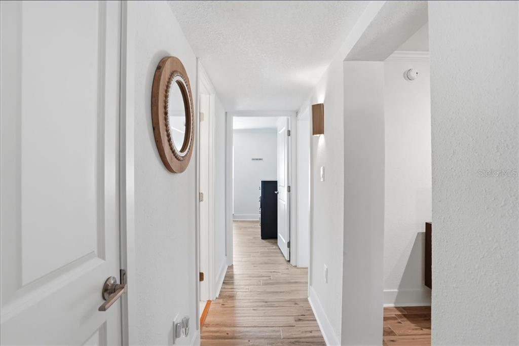 8911 Blind Pass Road, Unit 118 St. Pete Beach, FL 33706 - Photo 20 of 34 a view of a hallway with wooden floor