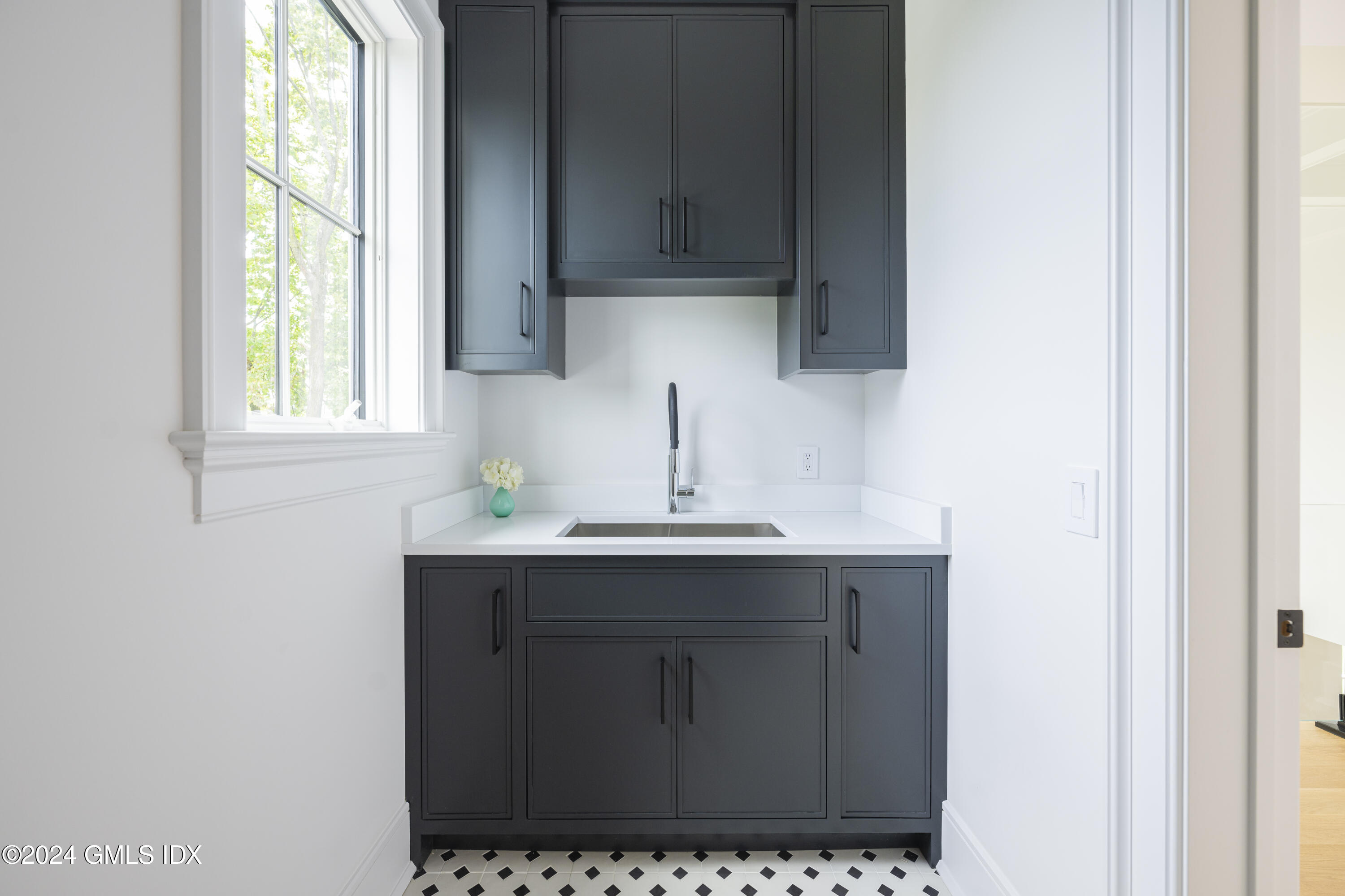 66 Ridge Street Greenwich, CT 06830 - Photo 25 of 40 a kitchen with a sink window and cabinets