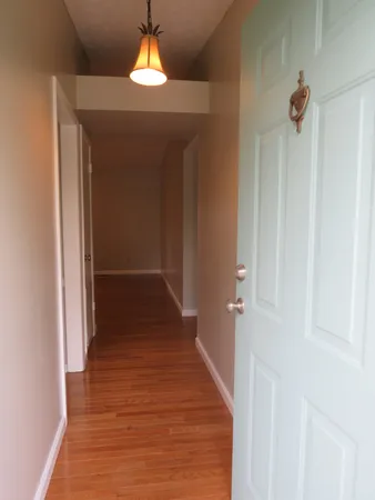 a view of a hallway with wooden floor and staircase