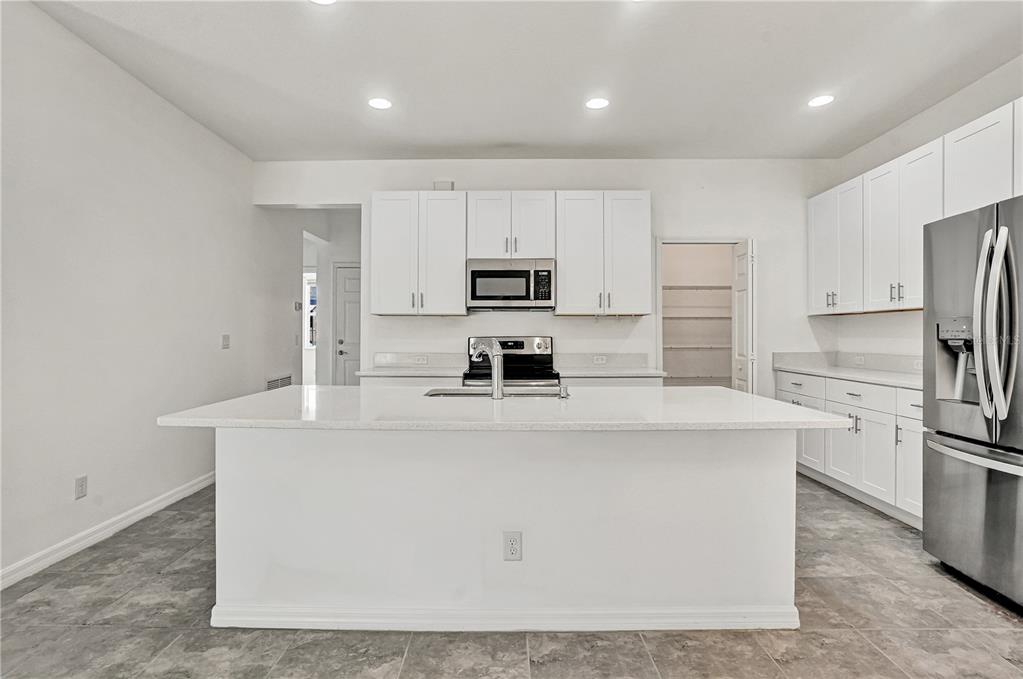 8544 Cache Drive Sarasota, FL 34240 - Photo 13 of 46 a kitchen with kitchen island a white cabinets and stainless steel appliances