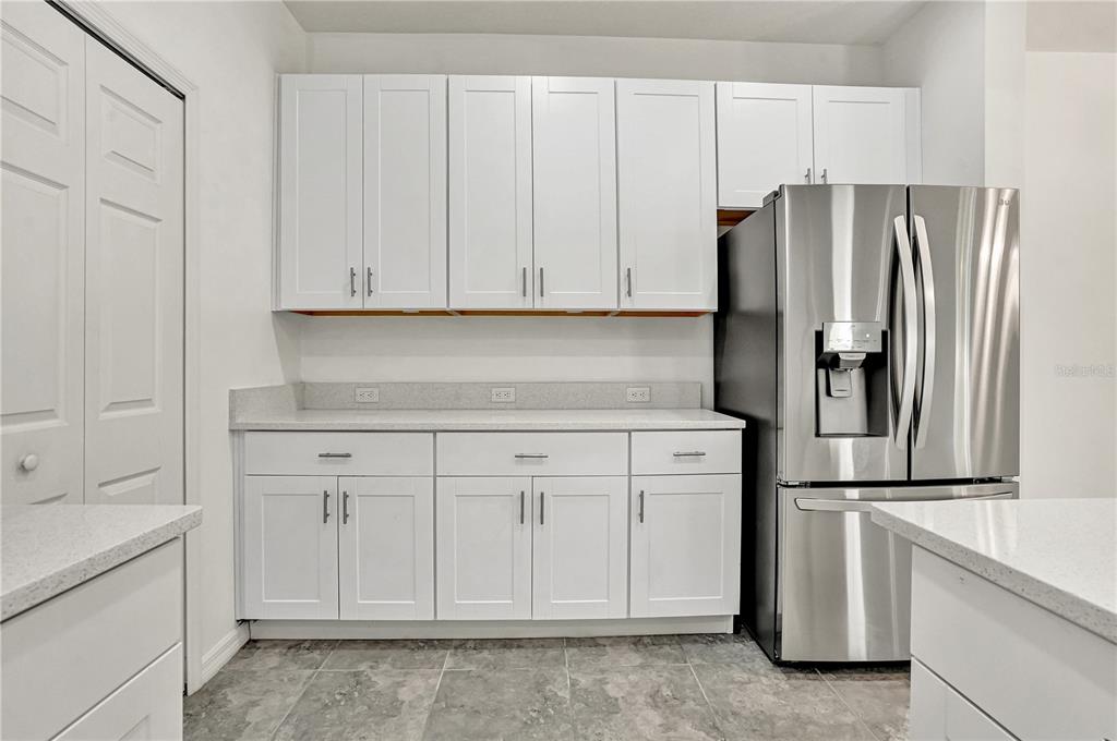 8544 Cache Drive Sarasota, FL 34240 - Photo 14 of 46 a kitchen with white cabinets and stainless steel appliances