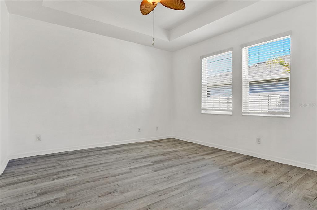 8544 Cache Drive Sarasota, FL 34240 - Photo 17 of 46 an empty room with wooden floor and windows