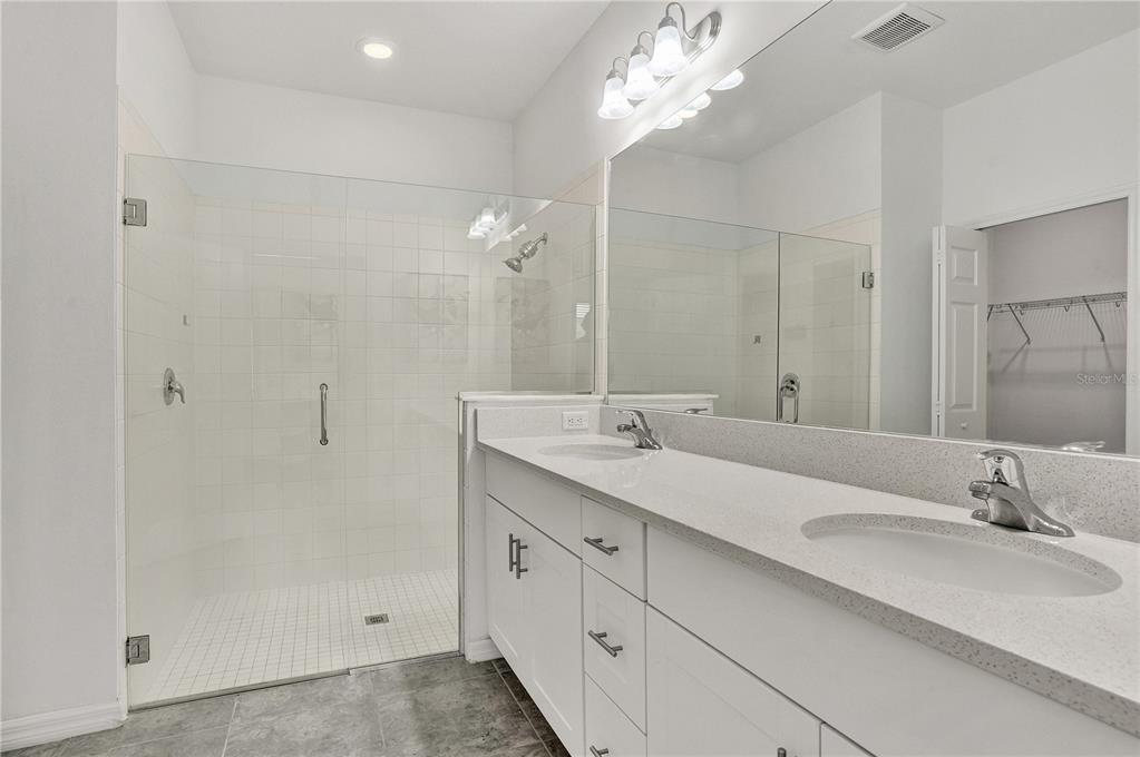 8544 Cache Drive Sarasota, FL 34240 - Photo 21 of 46 a bathroom with double vanity sinks and a mirror