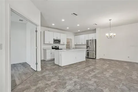 a large kitchen with white cabinets and stainless steel appliances