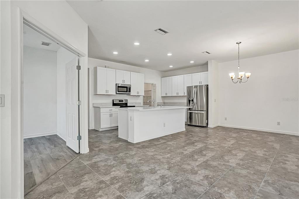 8544 Cache Drive Sarasota, FL 34240 - Photo 8 of 46 a large kitchen with white cabinets and stainless steel appliances