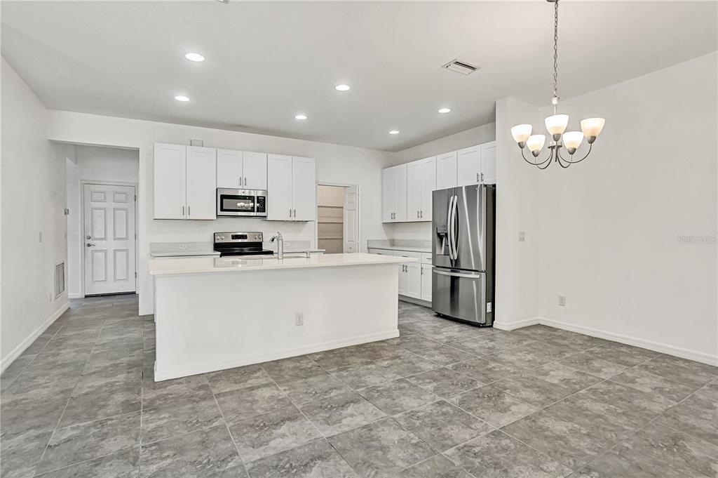 8544 Cache Drive Sarasota, FL 34240 - Photo 9 of 46 a kitchen with stainless steel appliances granite countertop a refrigerator a stove a sink and white cabinets