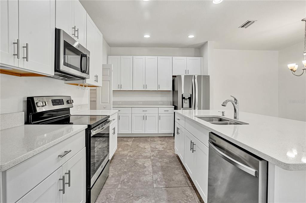 8544 Cache Drive Sarasota, FL 34240 - Photo 10 of 46 a kitchen with stainless steel appliances granite countertop a sink stove oven and refrigerator