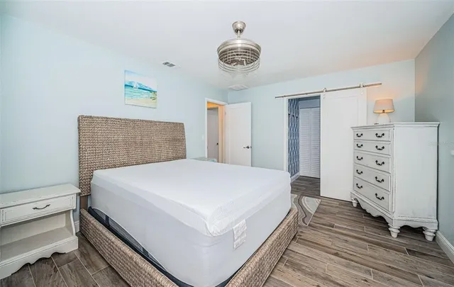 a bedroom with a bed and wooden floor