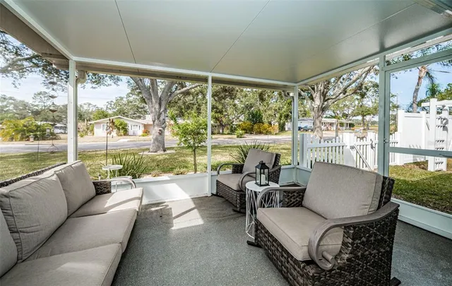 a living room with patio furniture and a floor to ceiling window