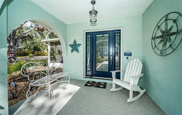 a living room with furniture a floor to ceiling window and potted plants