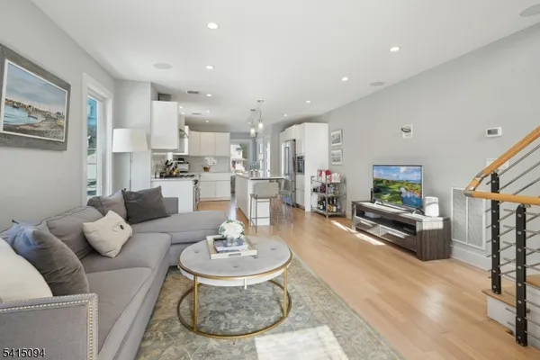 a living room with furniture and a dining table with wooden floor
