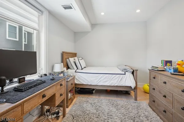 a spacious bedroom with a bed and a computer on the desk