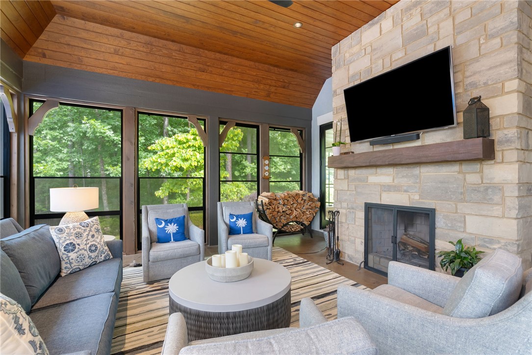 119 Drewberry Lane Sunset, SC 29685 - Photo 11 of 42 This inviting living area boasts a rustic ceiling and a stone fireplace, creating a cozy atmosphere right near the pool.